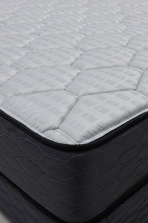 Close-up of a quilted mattress with dark sides.