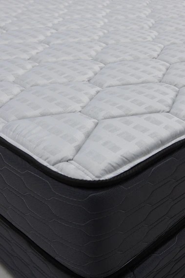 Close-up of a quilted mattress with dark sides.