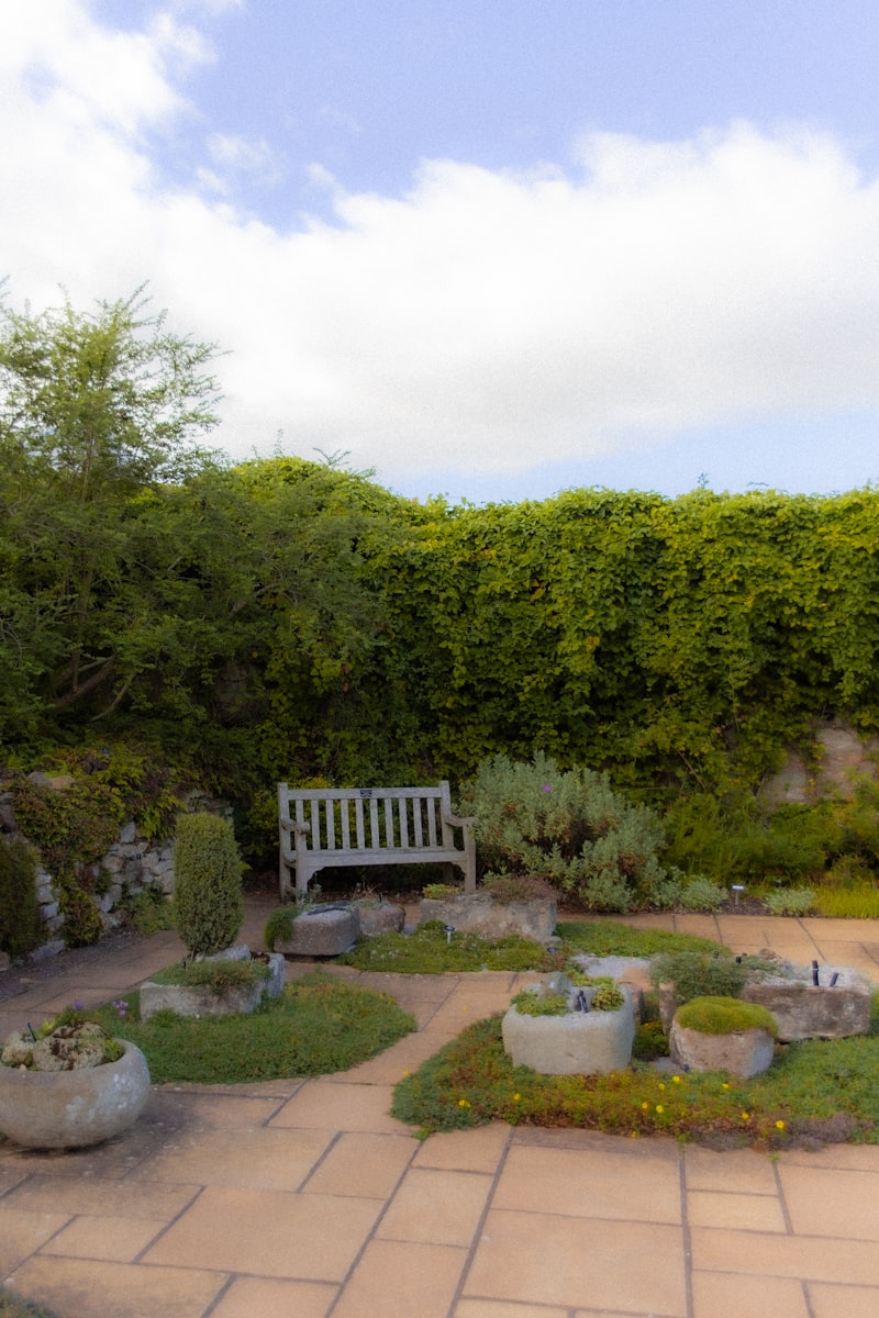 A peaceful garden with a wooden bench and stone planters