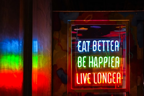 Neon sign reads eat better, be happier, live longer.
