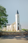 A white church with a tall steeple and clock.