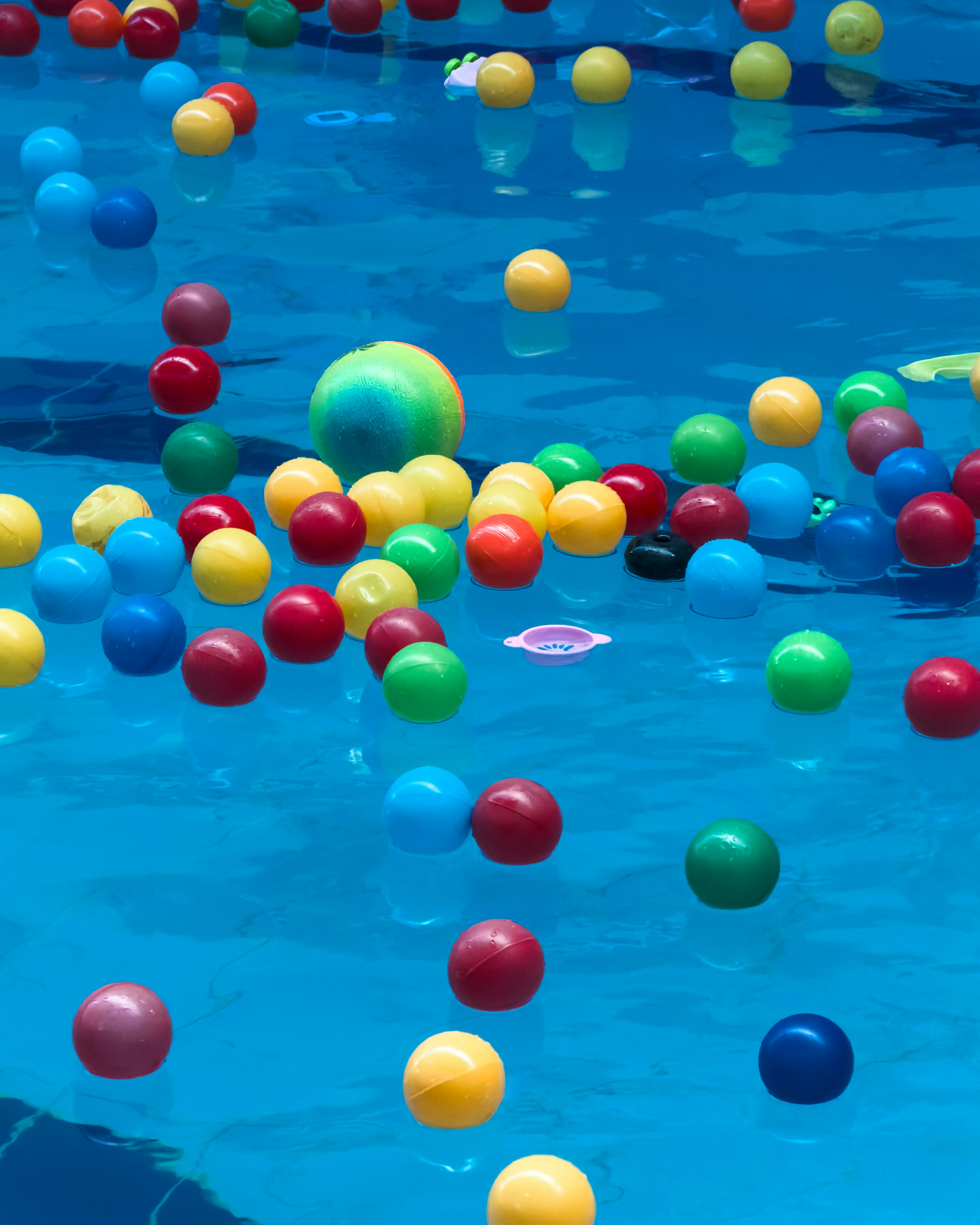 Colorful balls floating in a blue swimming pool.