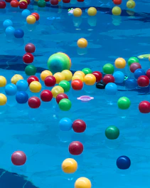 Colorful balls floating in a blue swimming pool.