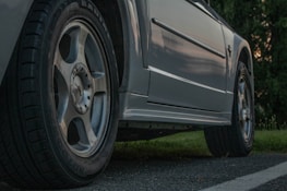 Close-up view of a gray vehicle's wheels and side