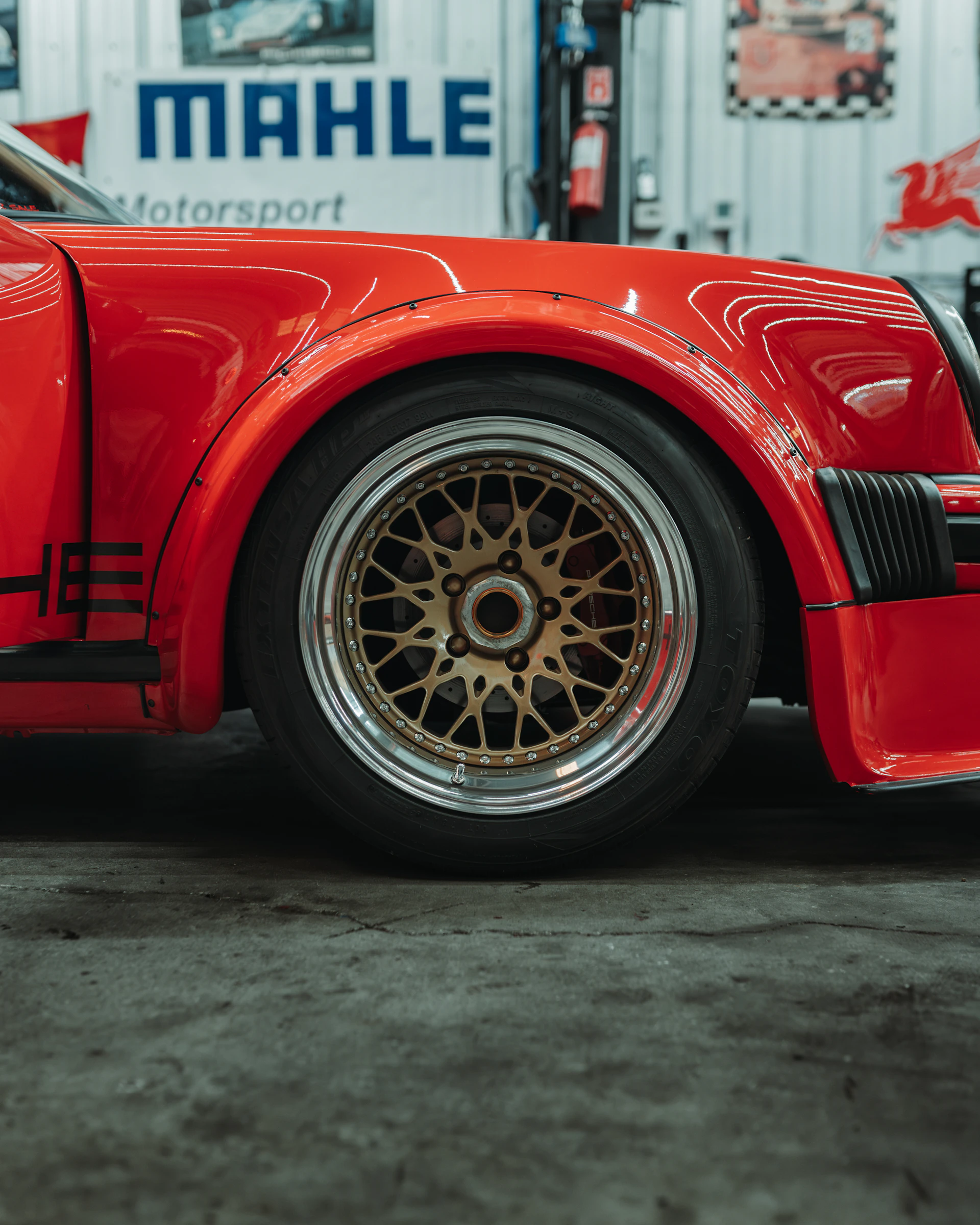 Red sports car wheel with gold bbs rims