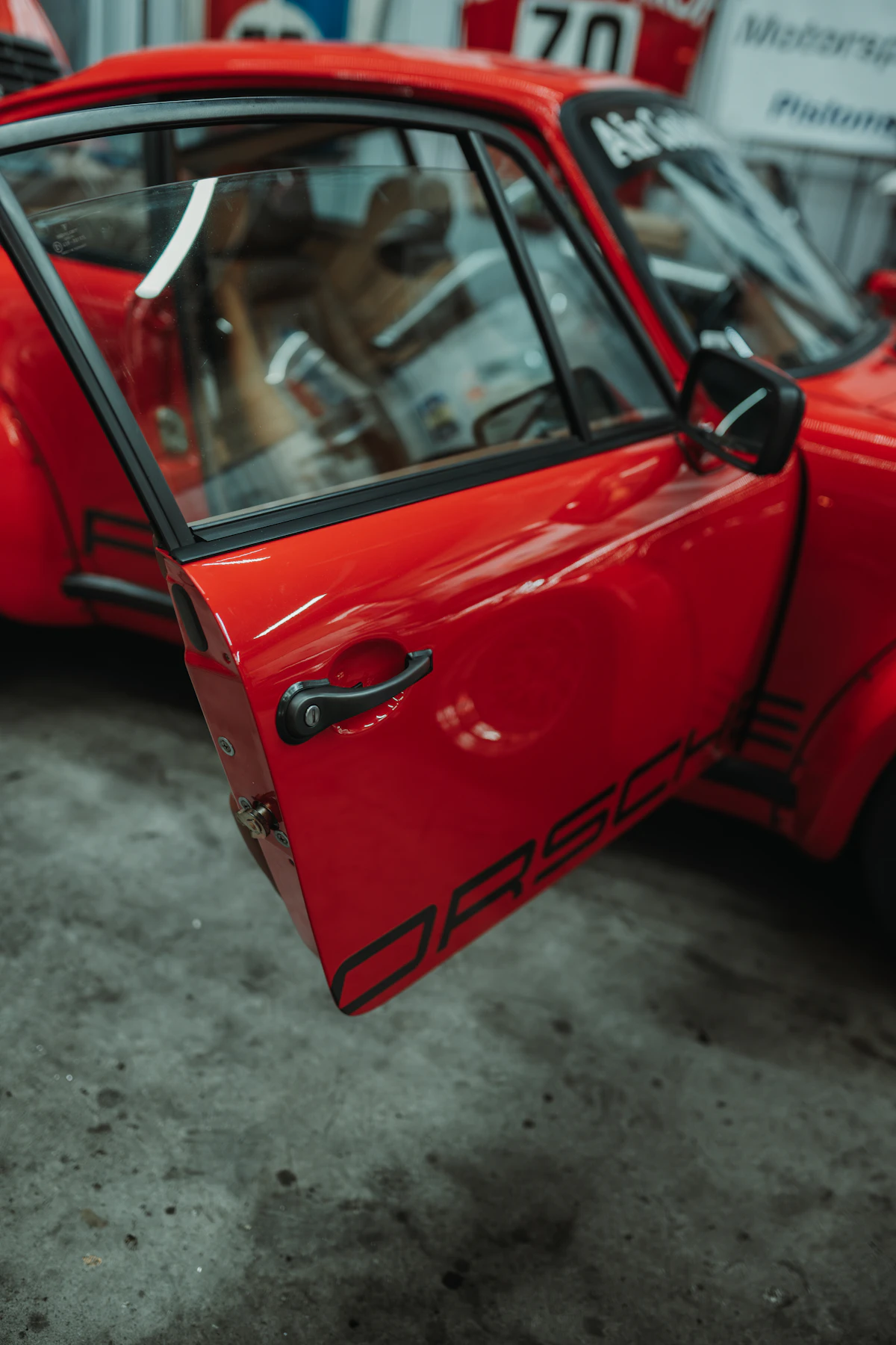 Red Porsche with open door showcasing premium paint finish and black accents