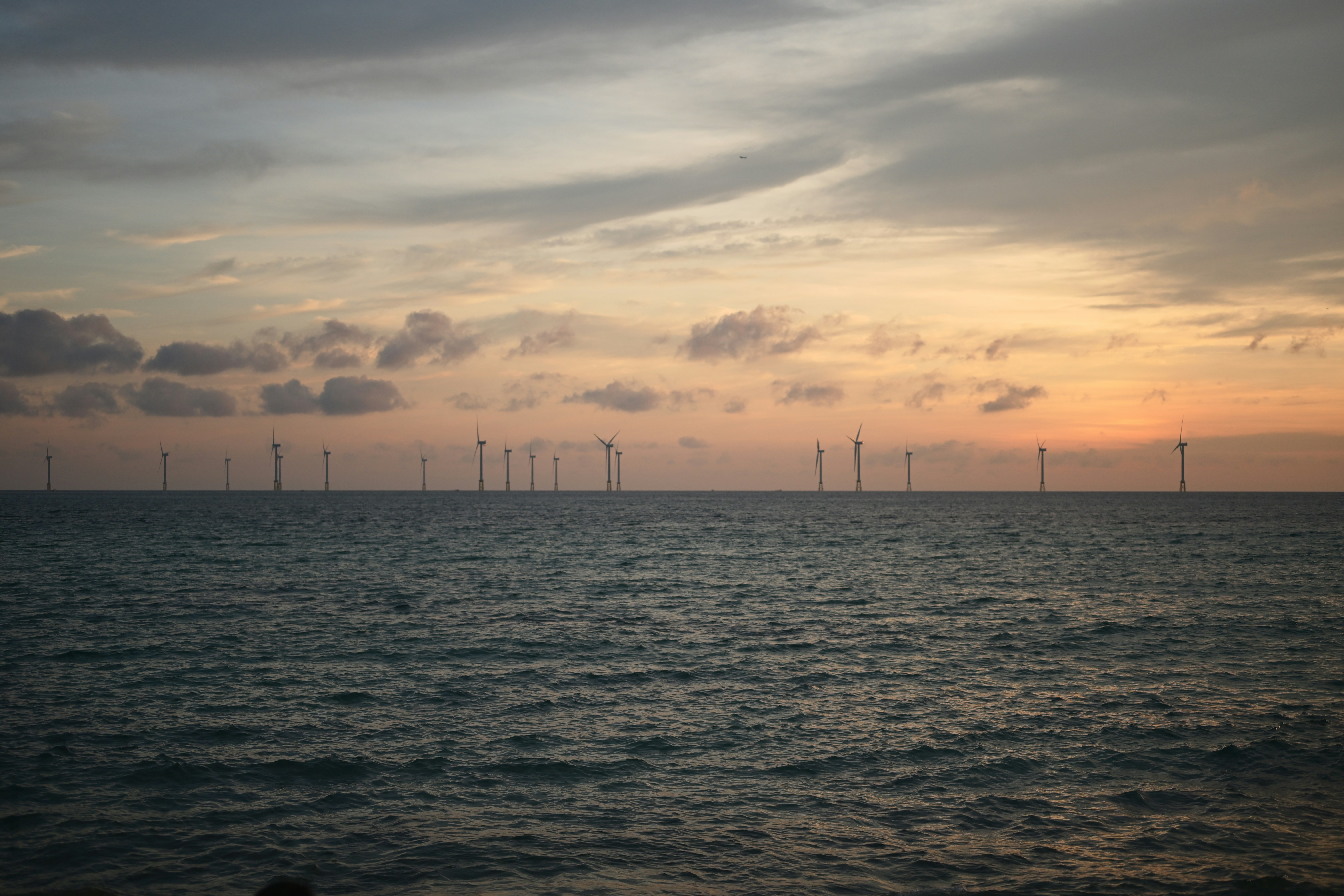 Ocean wind turbines at sunset