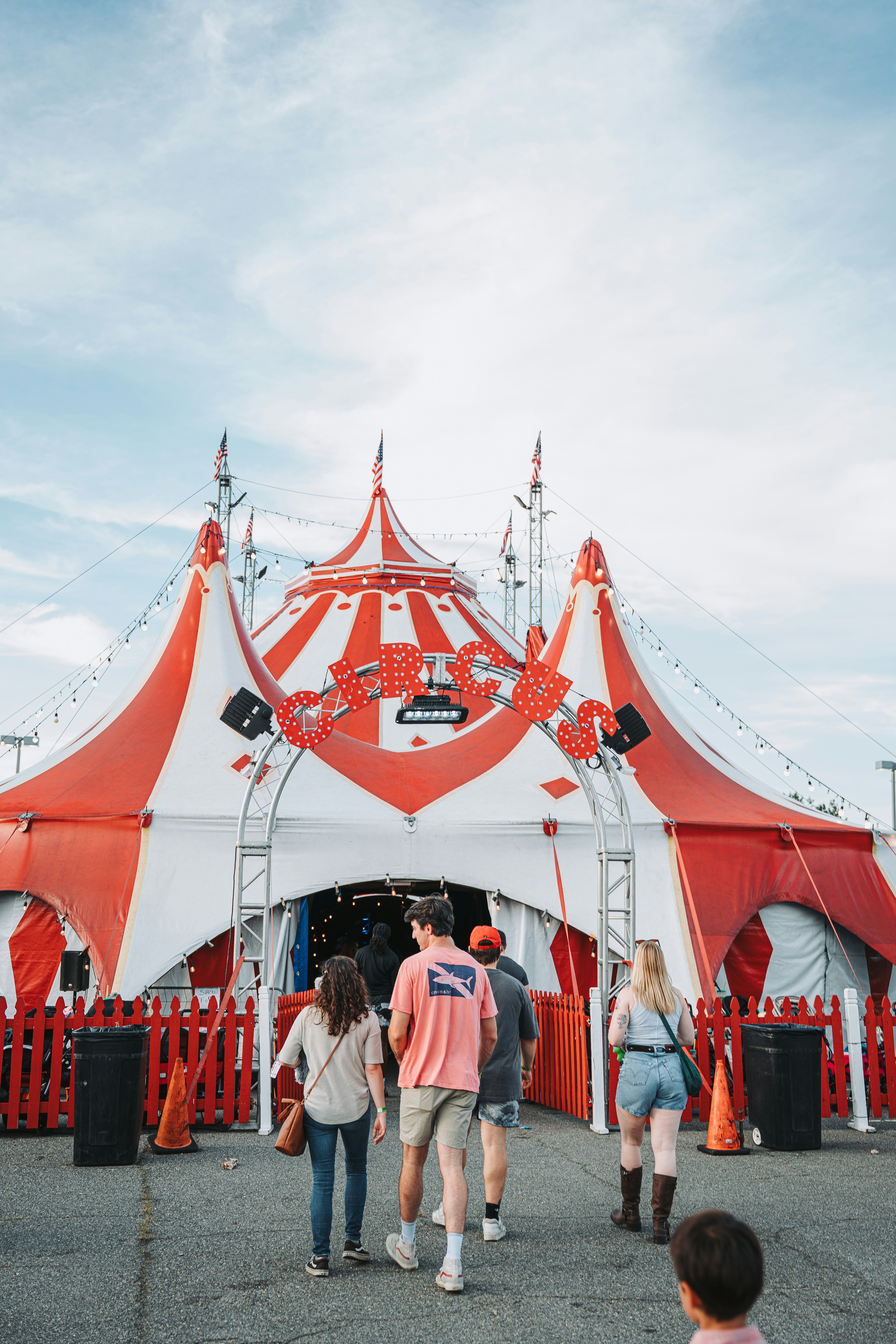 赤と白の縞模様のサーカステントに入る人々