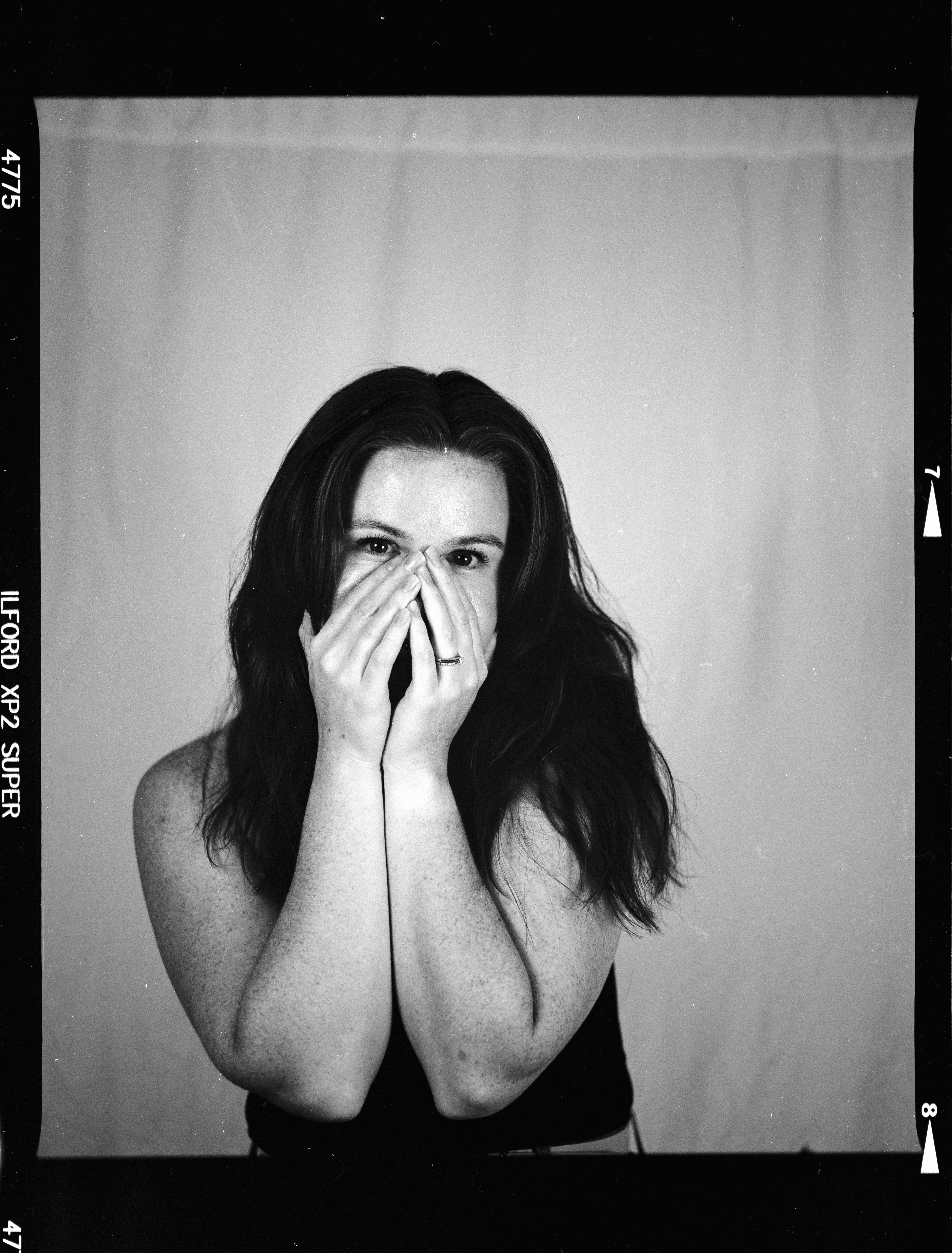 口と鼻を手で覆う女性