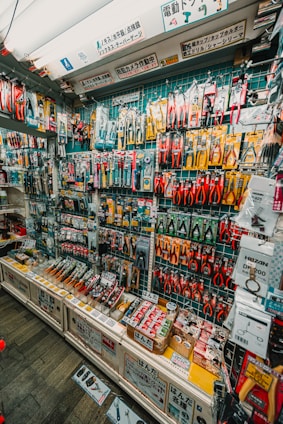 Wall display of assorted tools and hardware in a store.