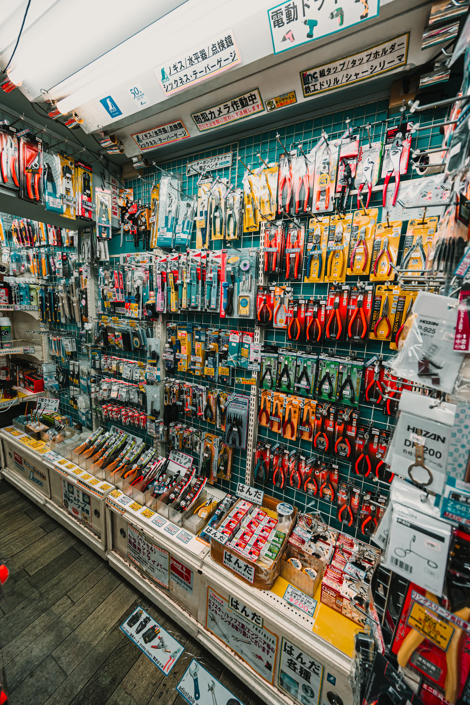 Wall display of assorted tools and hardware in a store.