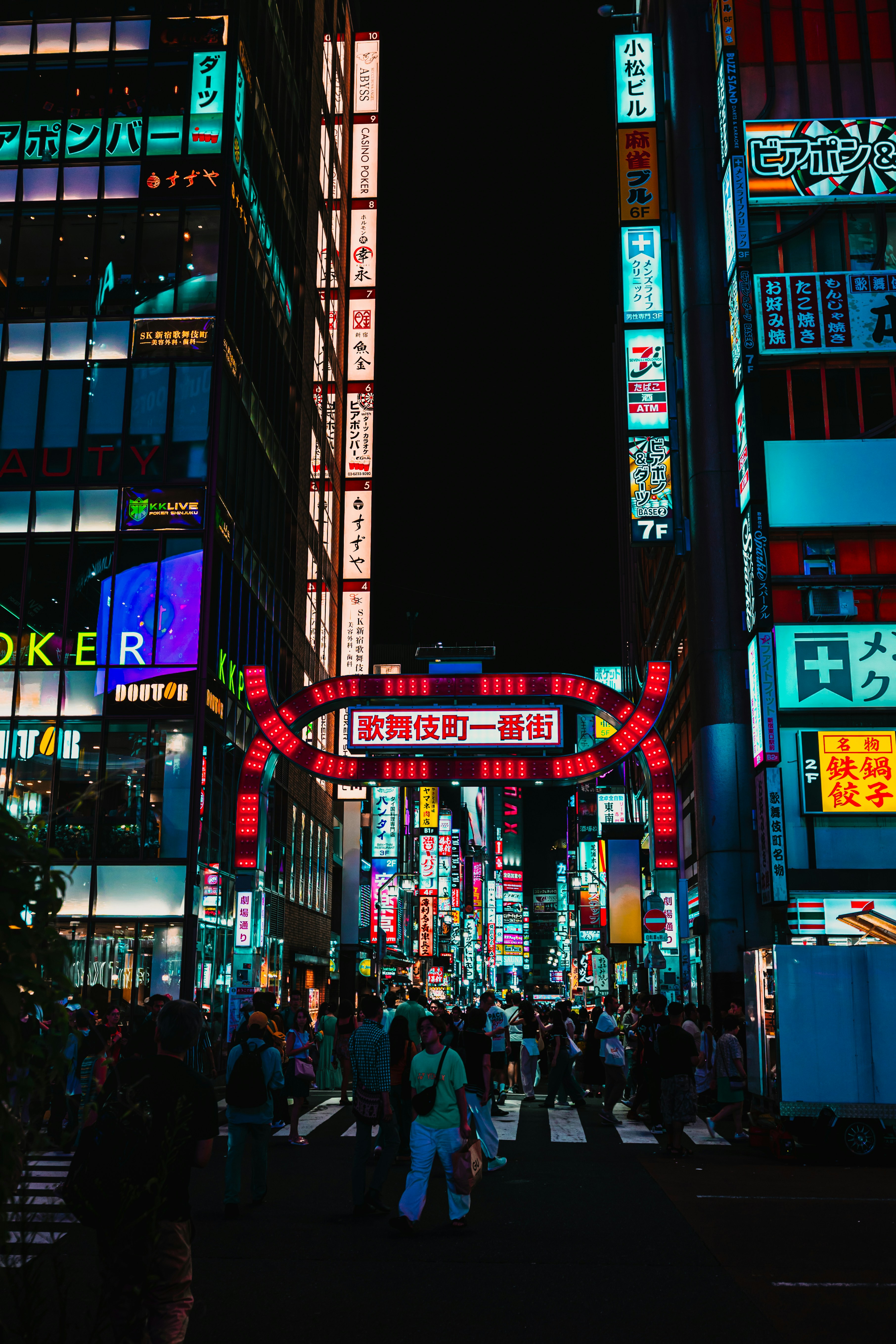 Vibrant neon signs illuminate a busy tokyo street at night.