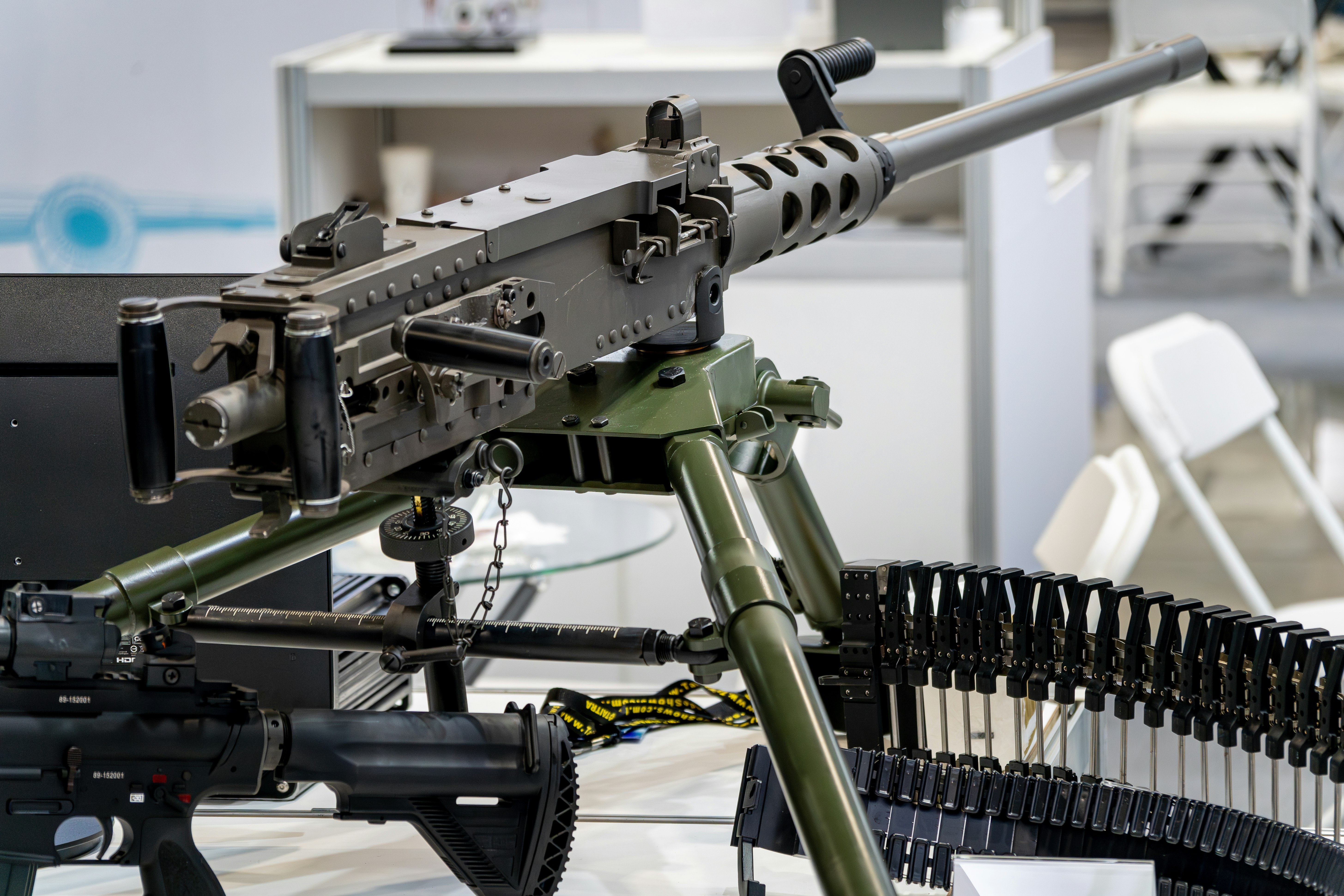 Heavy machine gun with ammunition belt on tripod.