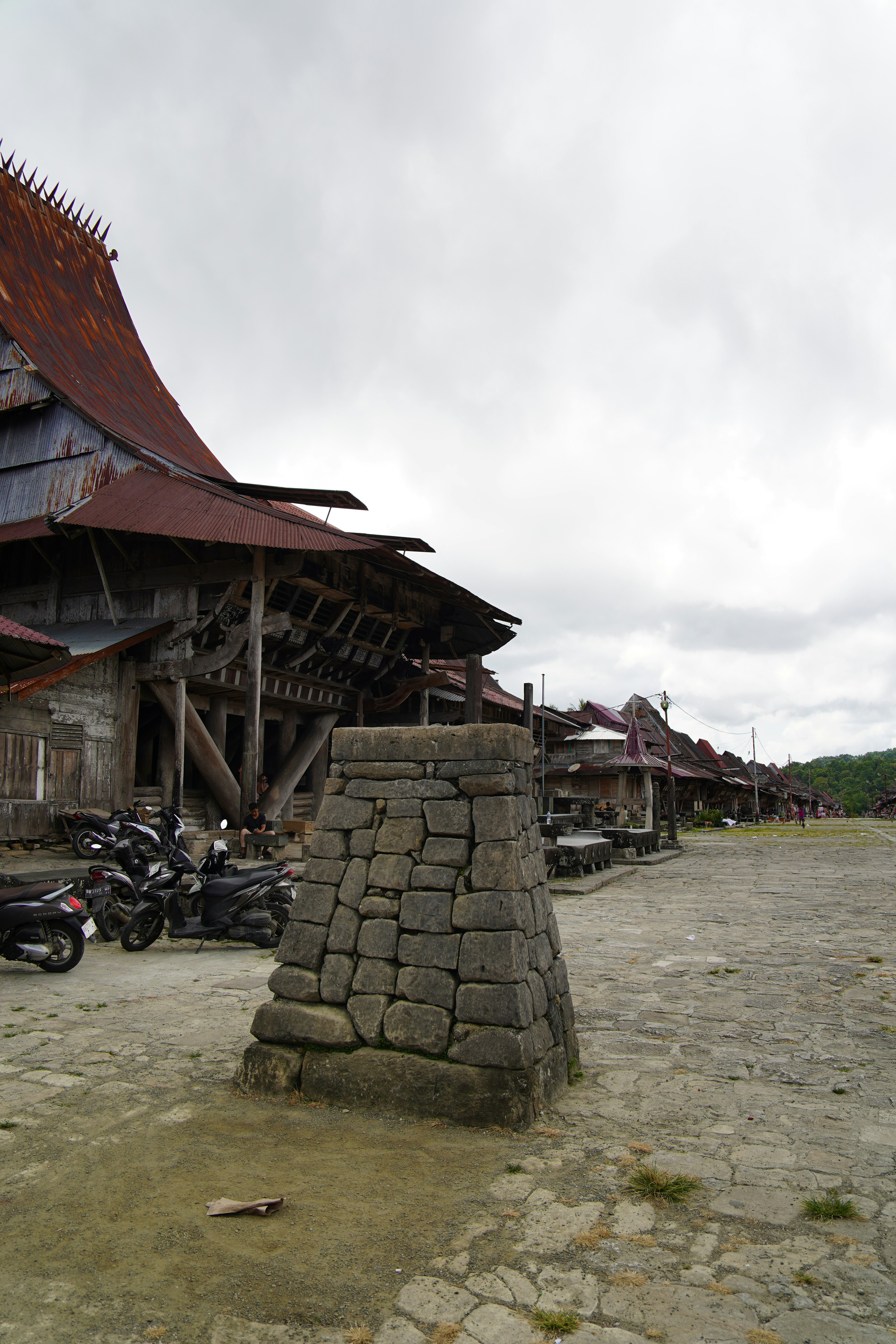 Stone monument in front of traditional village houses