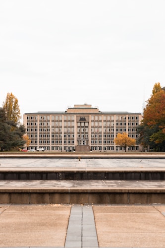 Grand institutional building surrounded by autumn trees, symbolizing the global central banking establishment