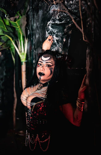 Woman with moon face paint and dark costume.