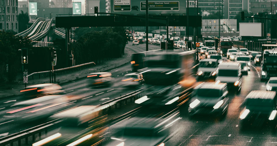 Busy highway with multiple lanes filled with cars, stretching down from side road perspective