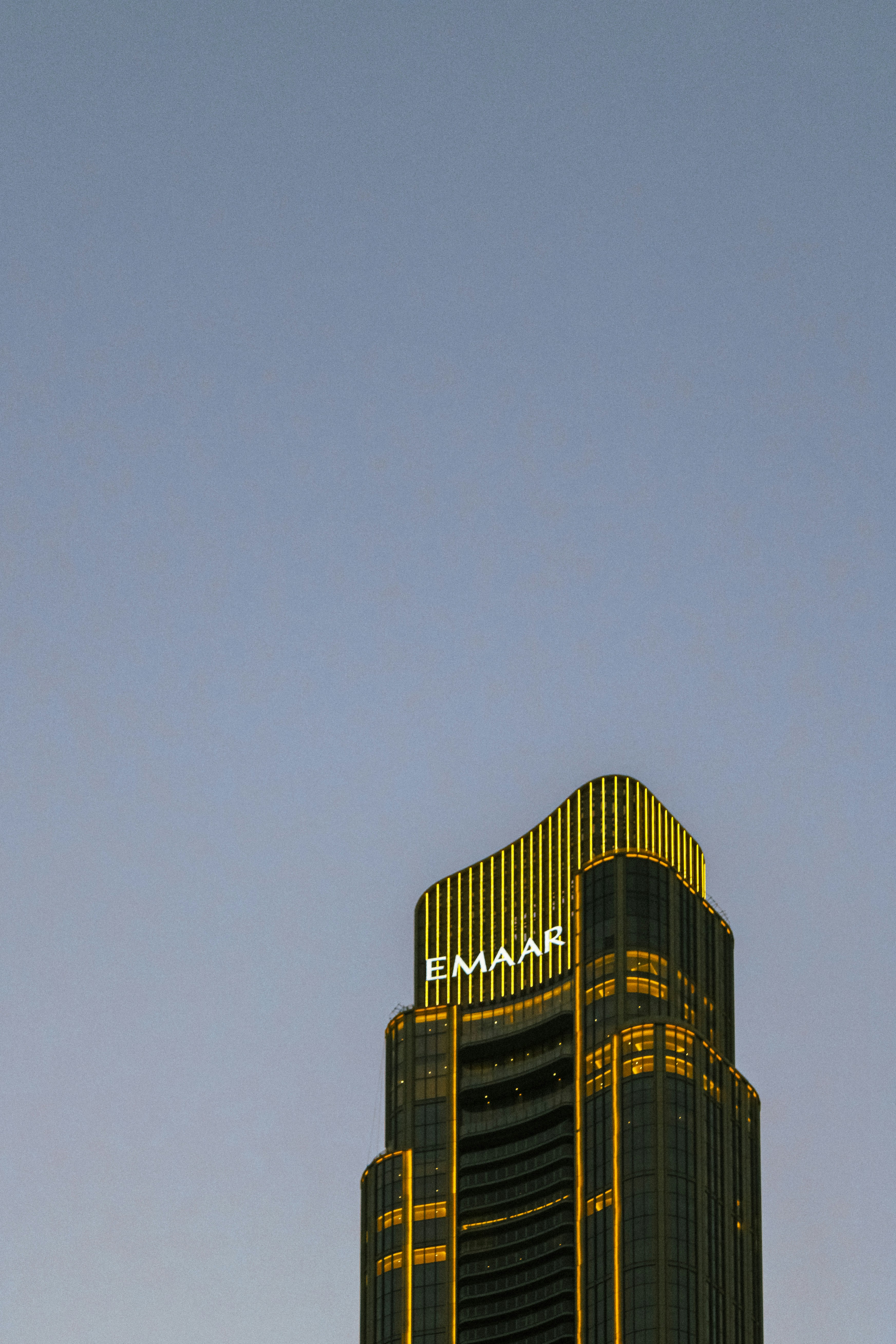 Modern skyscraper with emaar logo against clear sky.