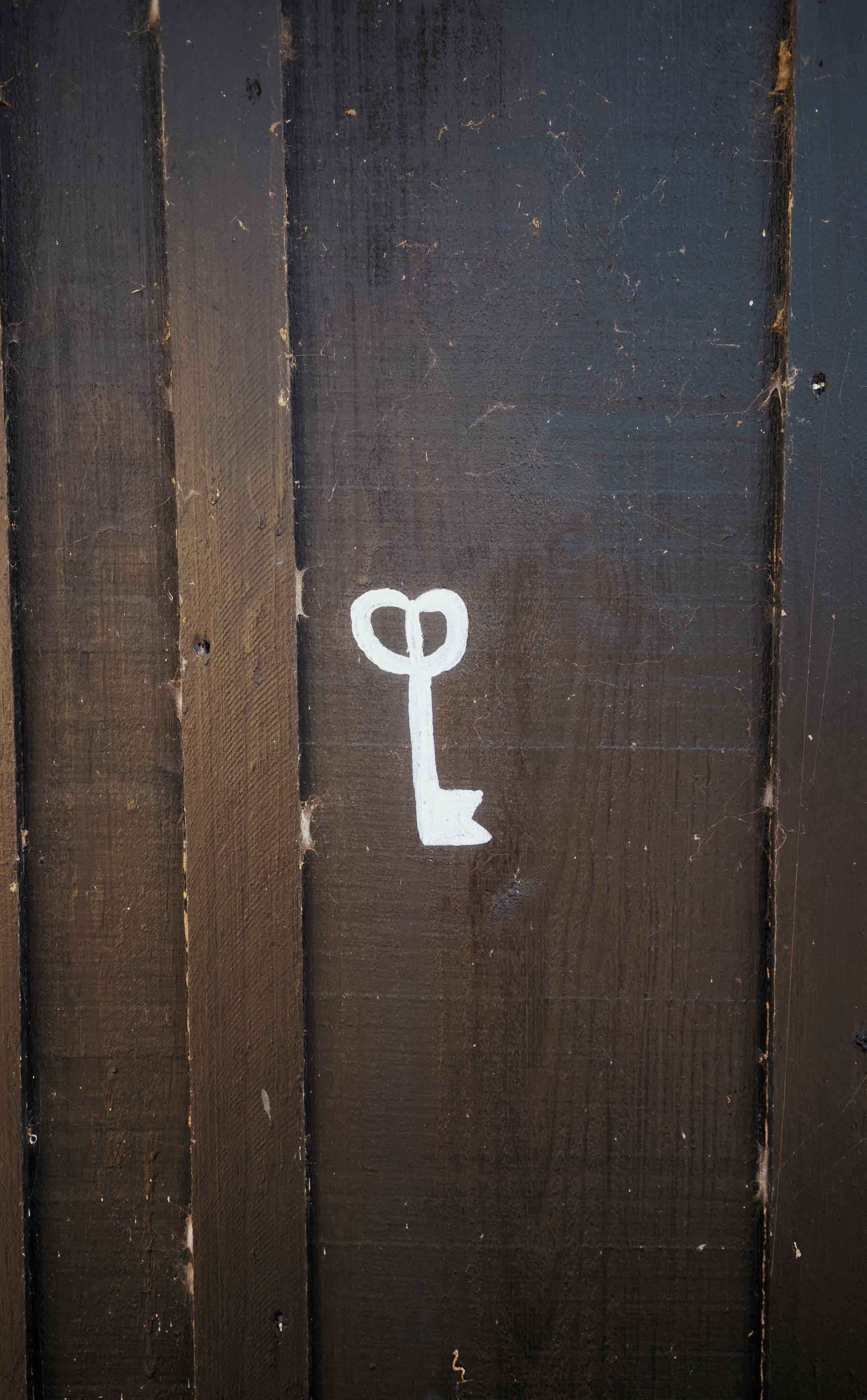 Symbole de clé sur une porte sombre évoquant une énigme d'escape game