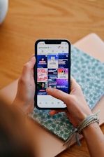 Hands holding phone displaying social media feed