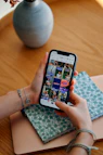 Hands holding smartphone displaying social media feed