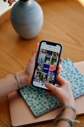 Hands holding smartphone displaying social media feed