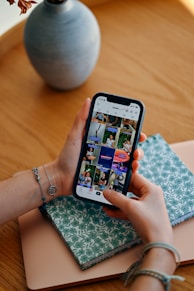 Hands holding smartphone displaying social media feed