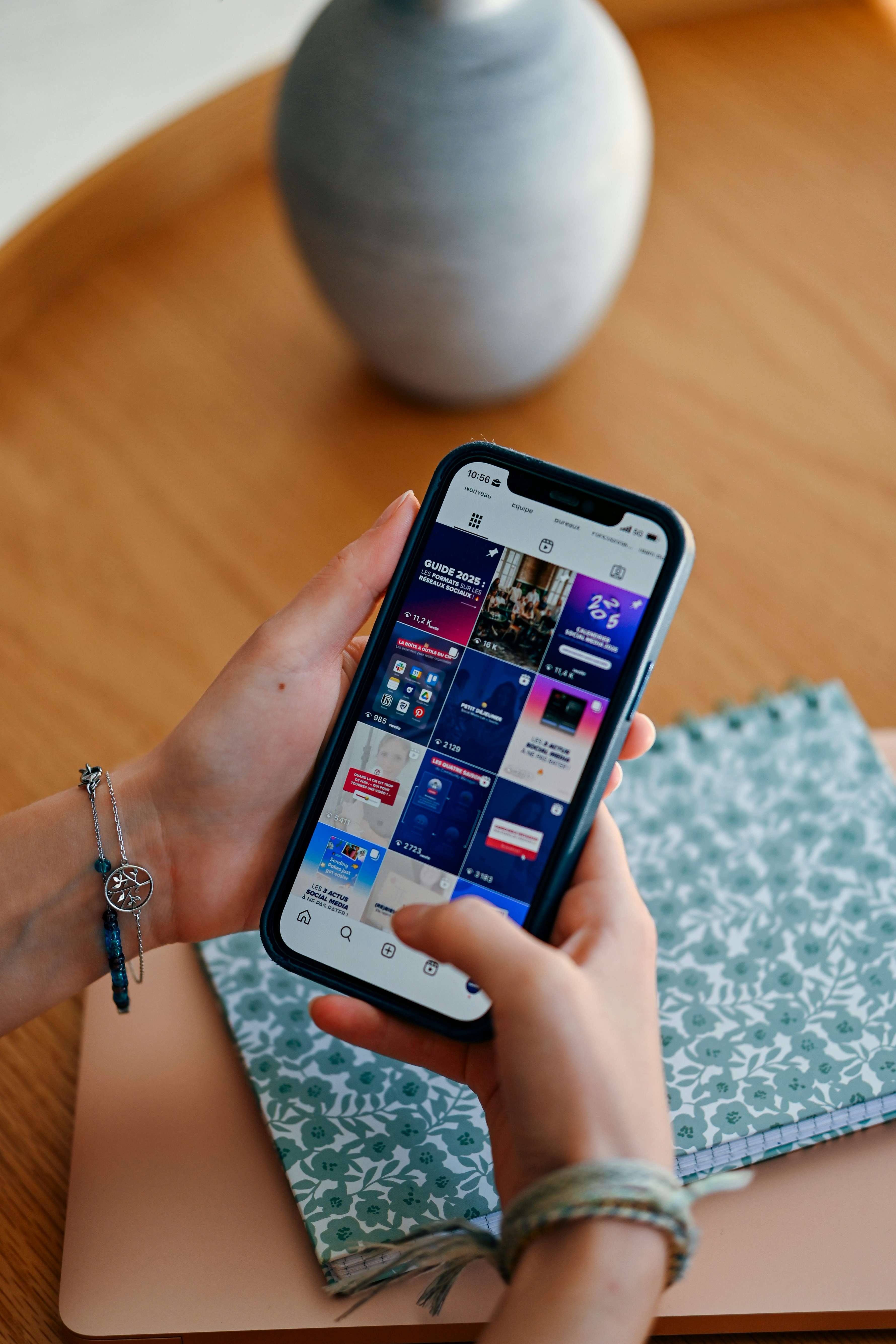 Manos sosteniendo un teléfono inteligente que muestra el feed de las redes sociales