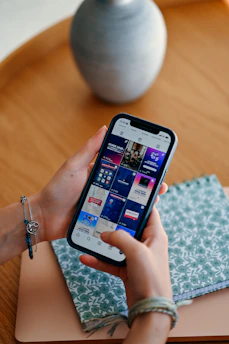 Hands holding a smartphone displaying social media feed