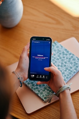 Hands holding a smartphone displaying a social media feed.