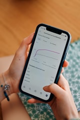 Person using smartphone to view social media analytics.