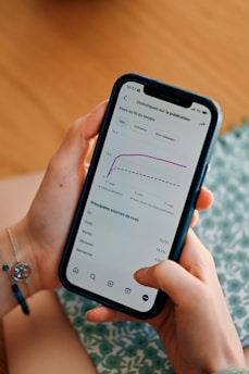 Person using smartphone to view social media analytics.