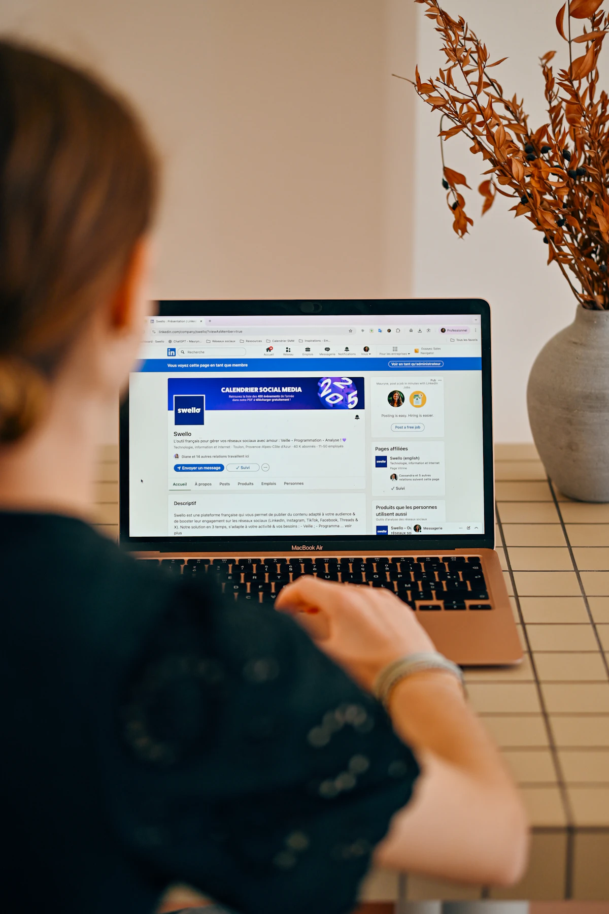 Social media manager reviewing digital content and a business profile on a laptop