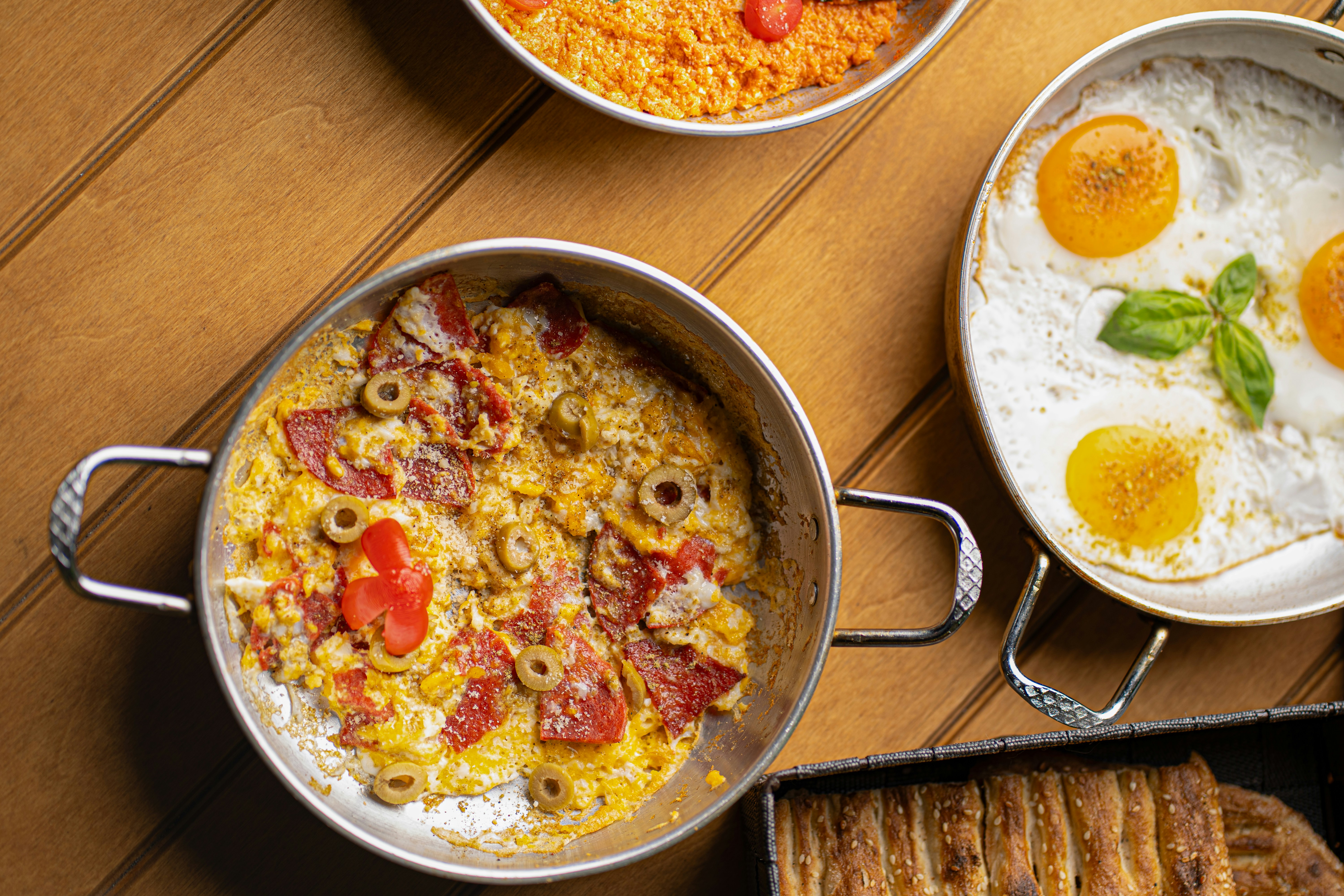 Scrambled eggs with ham and olives, fried eggs, and rice.