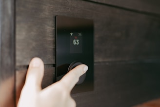 Hand stellt ein digitales Smart-Home-Thermostat ein.