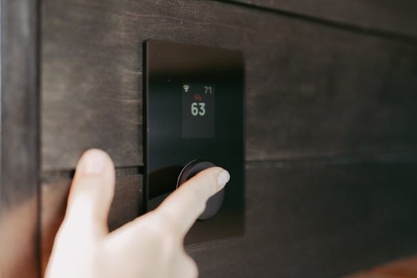 Hand adjusting a digital thermostat display