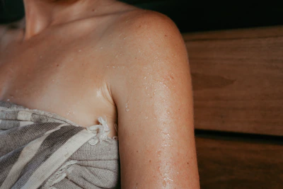 Woman's sweaty shoulder wrapped in towel