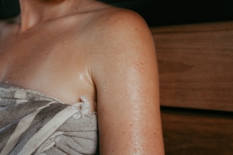 Woman's sweaty shoulder wrapped in towel