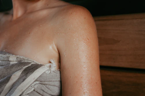 Woman's sweaty shoulder wrapped in towel