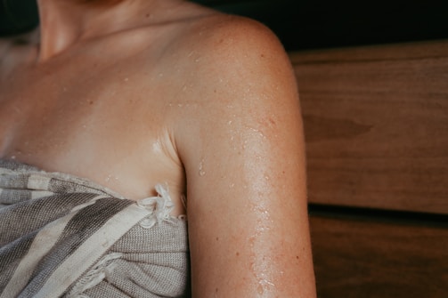 Woman's sweaty shoulder wrapped in towel
