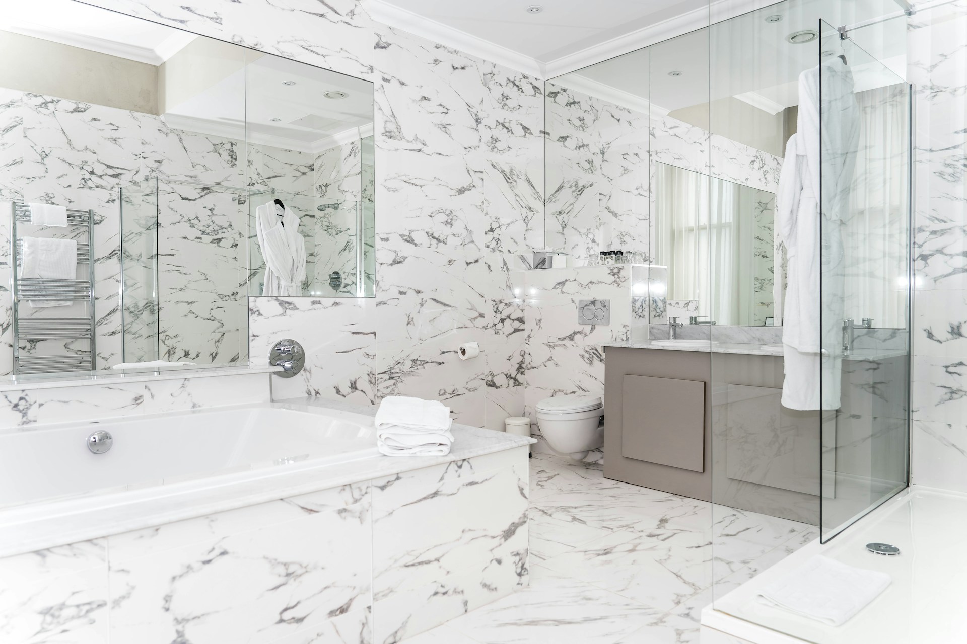 Luxurious marble bathroom with bathtub and vanity.