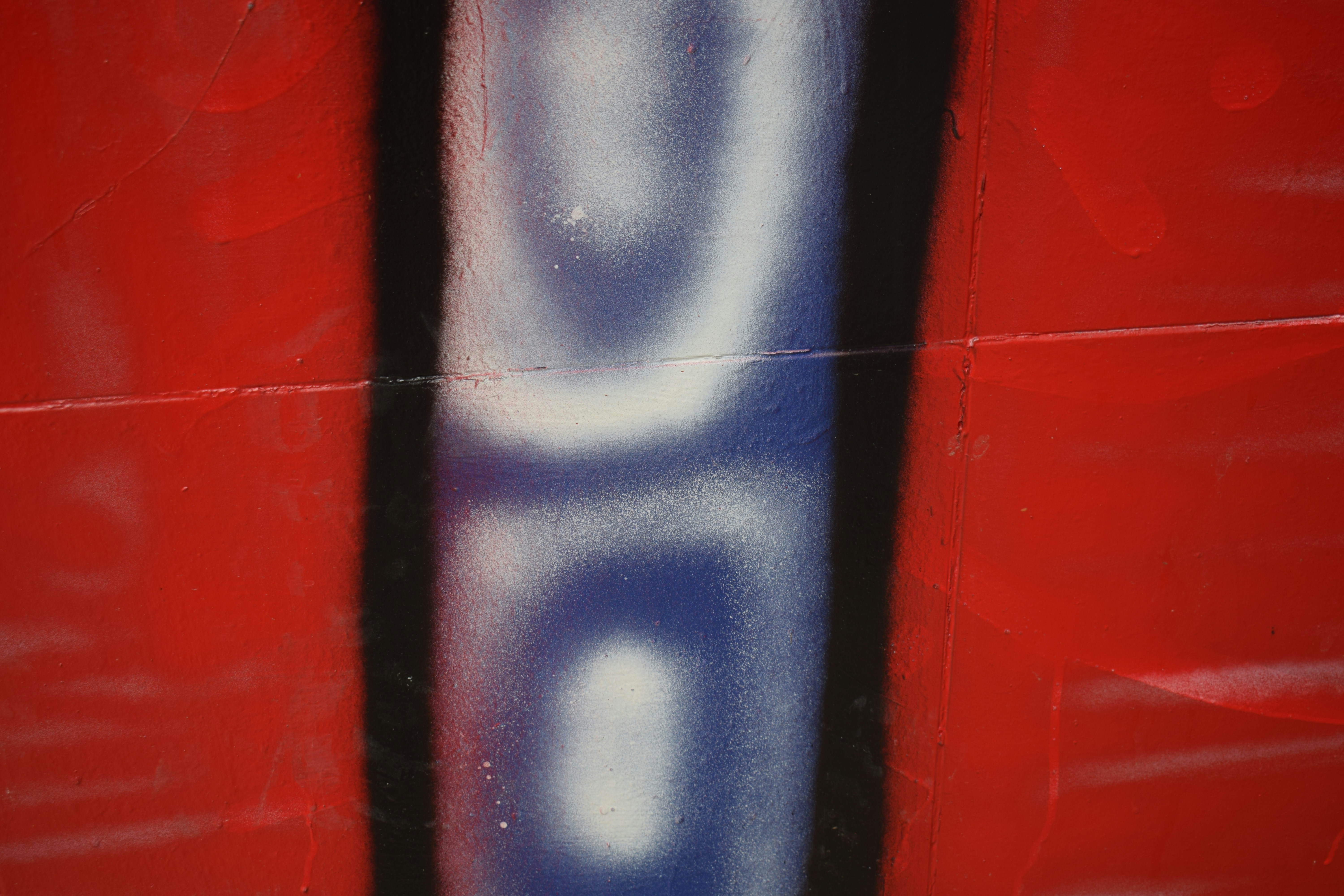 Red background with vertical blue and white abstract design