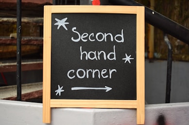 Black chalkboard sign reads "second hand corner".