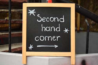 Black chalkboard sign reads "second hand corner".