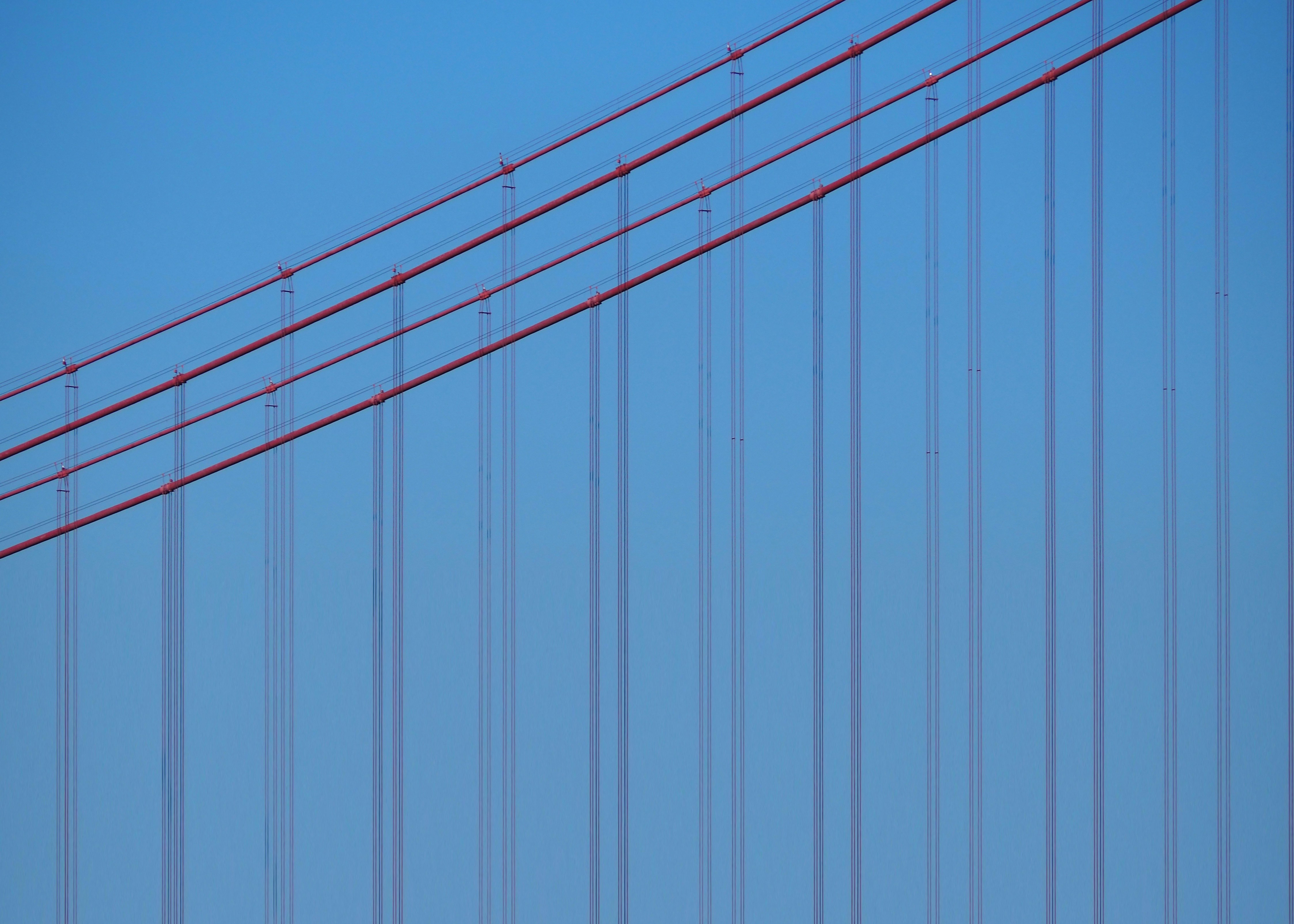 Cavi di sospensione rossi contro un cielo azzurro e limpido