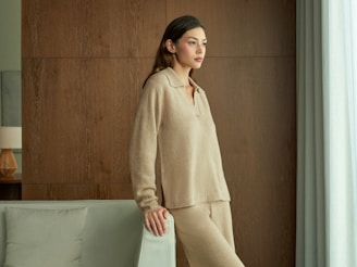 Woman in beige loungewear looking out window