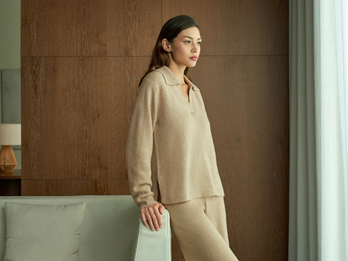 Model in beige loungewear beside a window