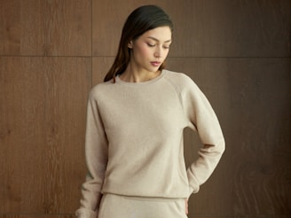 A woman wearing a beige sweater and pants.