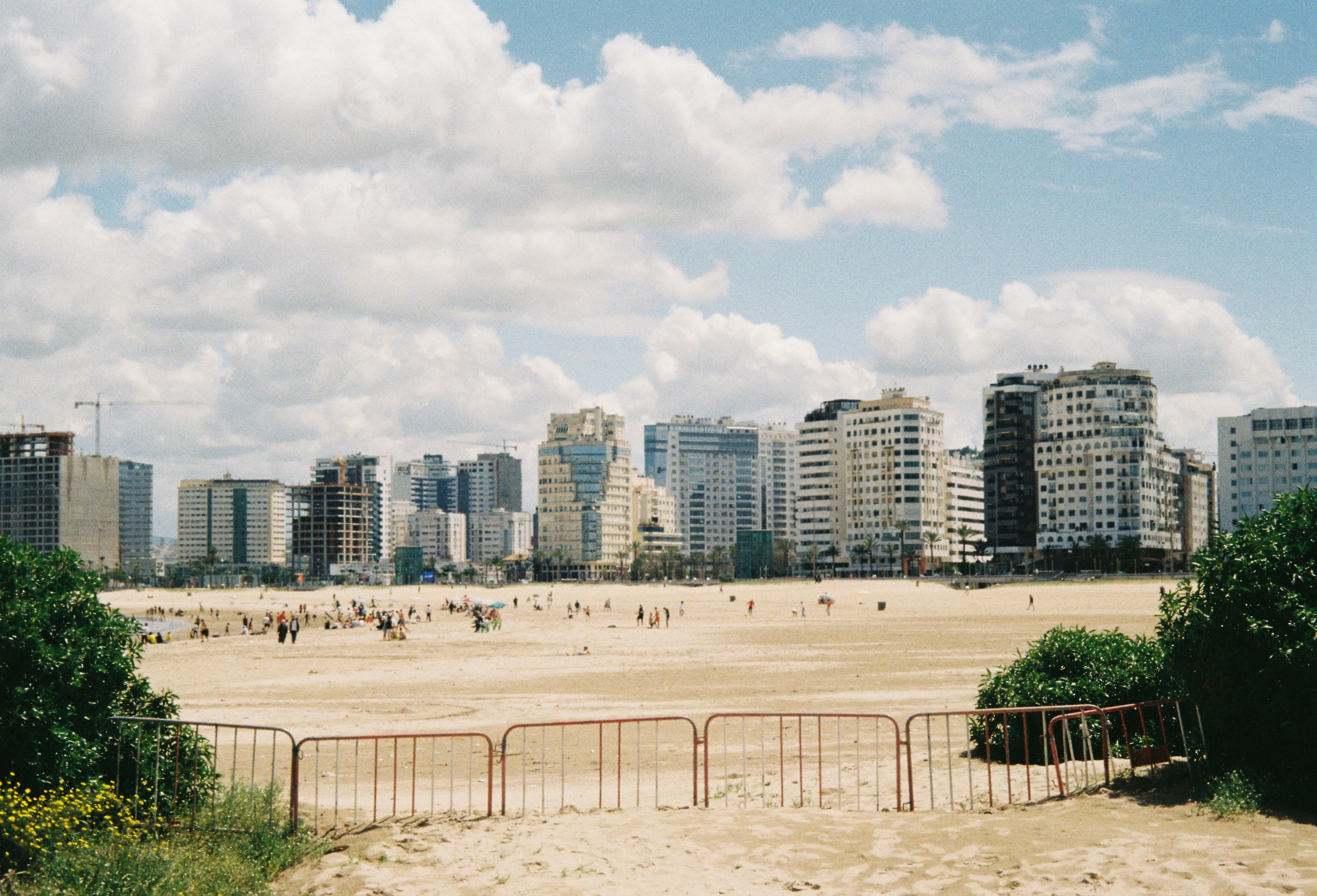 Skyline der Stadt hinter einem Sandstrand mit Menschen.