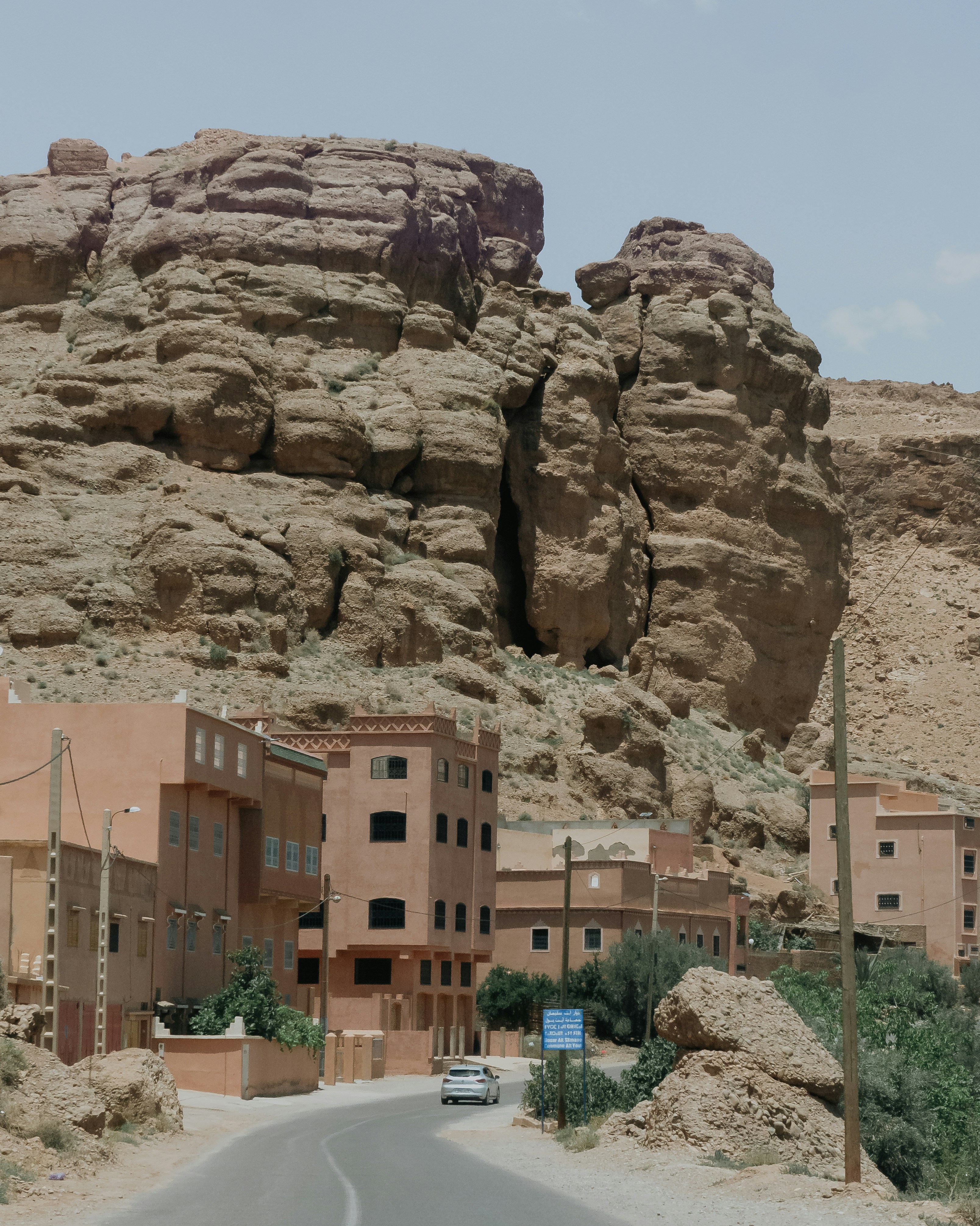 Ein Wüstendorf unter hoch aufragenden Felsformationen.